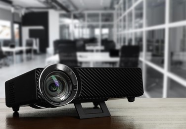 Image of Modern video projector on wooden table in office