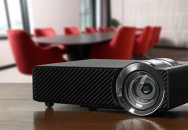 Image of Modern video projector on wooden table in conference room