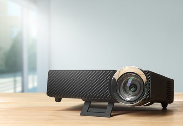 Image of Modern video projector on wooden table in room
