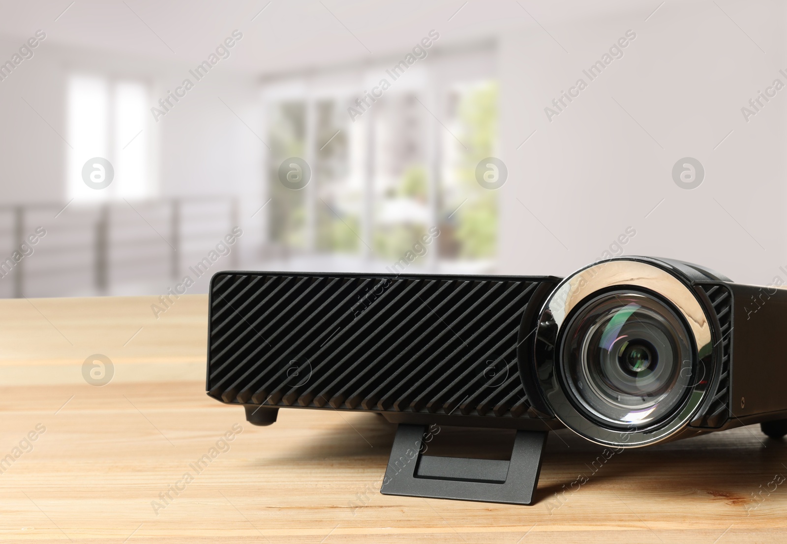Modern video projector on wooden table in room Image of Modern video projector on wooden table in room