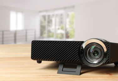 Image of Modern video projector on wooden table in room