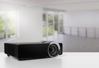 Image of Modern video projector on white table in room