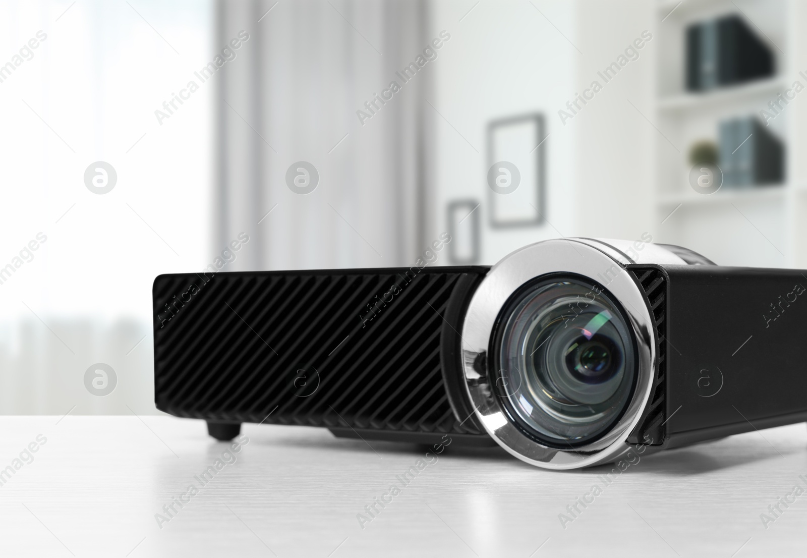 Modern video projector on white table in office Image of Modern video projector on white table in office