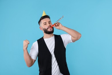 Photo of Happy Birthday. Handsome man with party hat and blower on light blue background