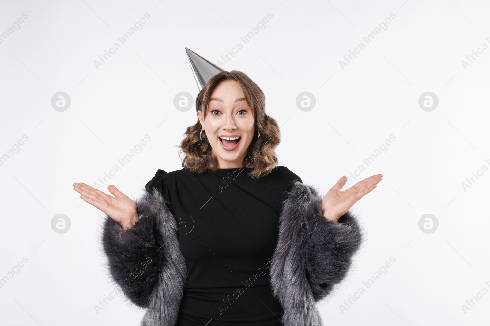 Birthday celebration. Excited woman with party cone on white background Photo of Birthday celebration. Excited woman with party cone on white background