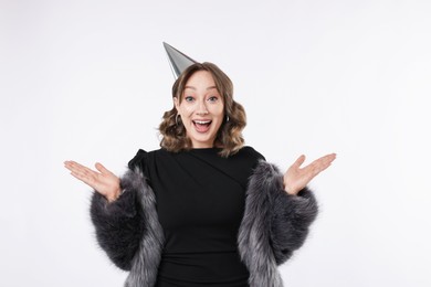 Photo of Birthday celebration. Excited woman with party cone on white background
