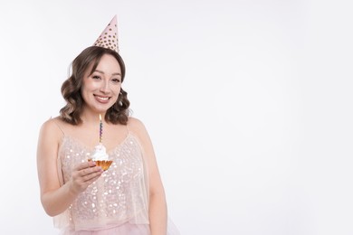Photo of Birthday celebration. Woman with cupcake on white background. Space for text