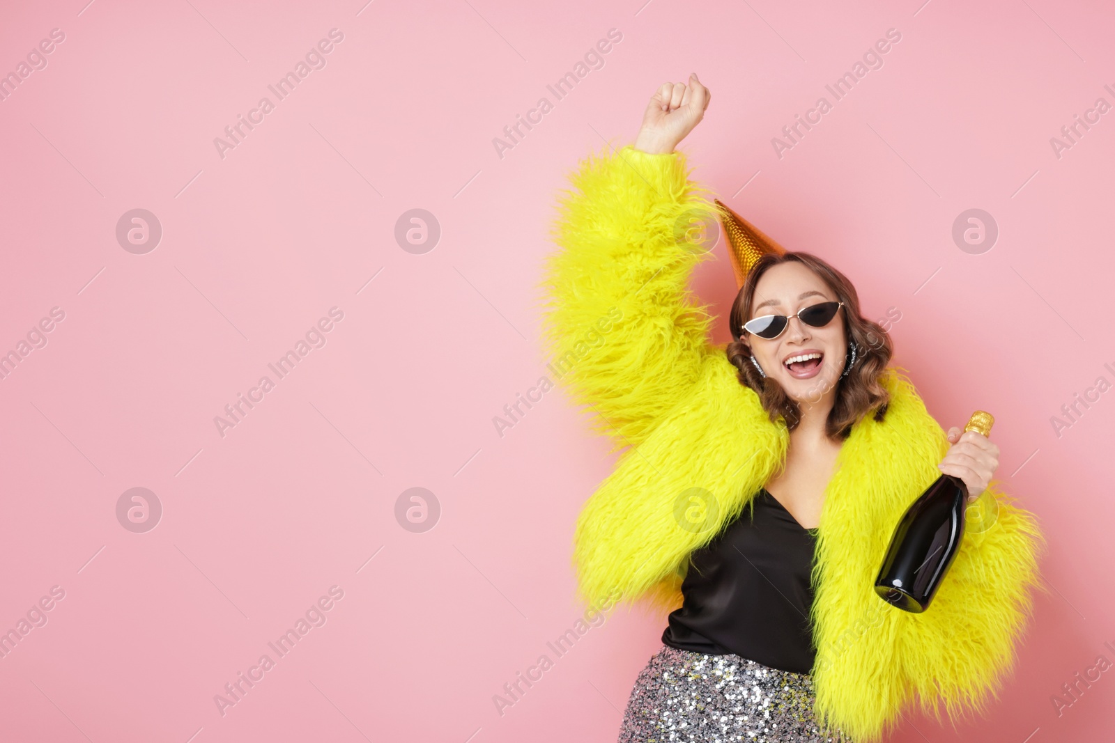 Birthday celebration. Woman with sparkling wine on pink background. Space for text Photo of Birthday celebration. Woman with sparkling wine on pink background. Space for text