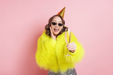 Photo of Birthday celebration. Woman with glass of sparkling wine on pink background
