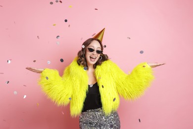Photo of Birthday celebration. Woman on pink background with confetti
