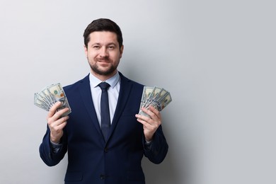 Photo of Greedy banker with dollar banknotes on grey background. Space for text