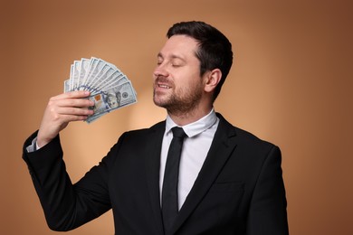 Photo of Happy greedy banker with dollar banknotes on golden background