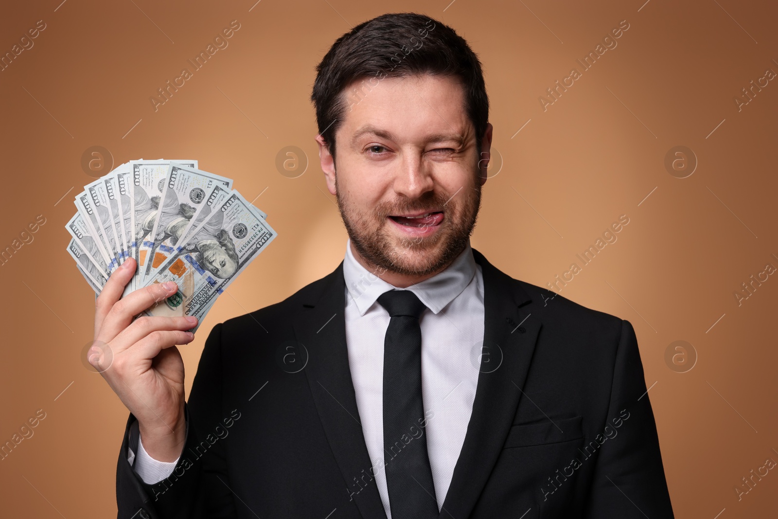 Funny greedy banker with dollar banknotes on golden background Photo of Funny greedy banker with dollar banknotes on golden background
