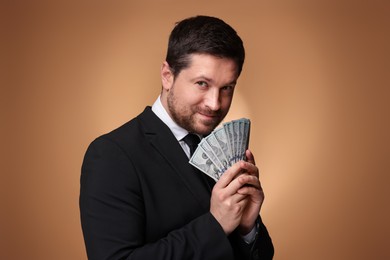 Photo of Greedy banker with dollar banknotes on golden background
