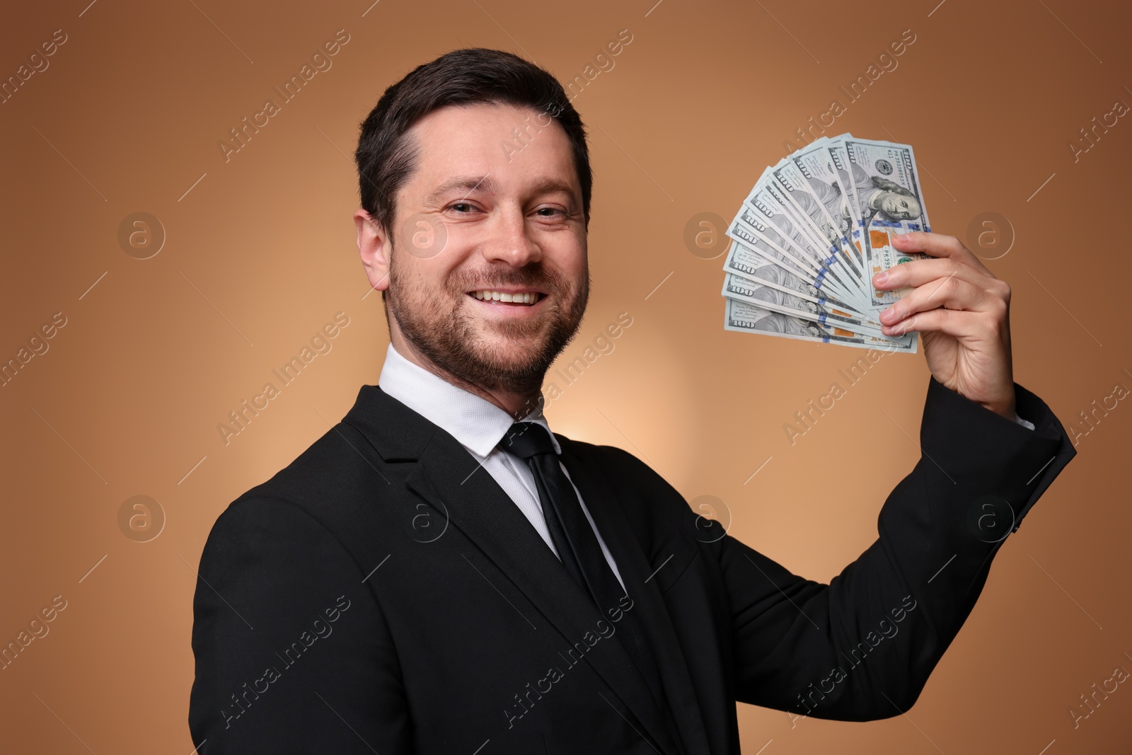 Happy greedy banker with dollar banknotes on golden background Photo of Happy greedy banker with dollar banknotes on golden background