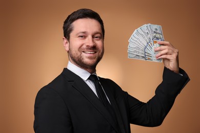 Photo of Happy greedy banker with dollar banknotes on golden background