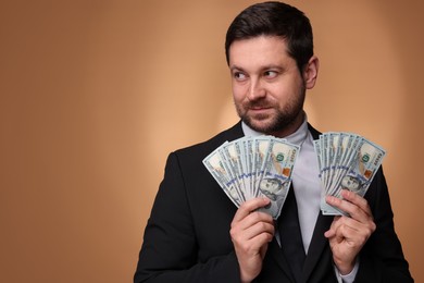 Photo of Greedy banker with dollar banknotes on golden background. Space for text