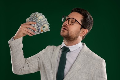 Photo of Greedy banker waving money on green background