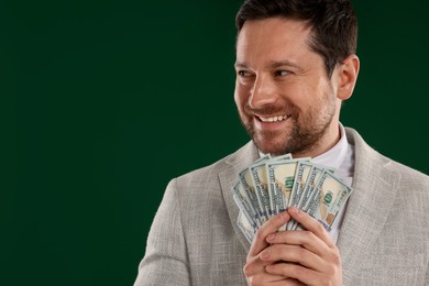 Photo of Happy greedy banker with dollar banknotes on green background. Space for text