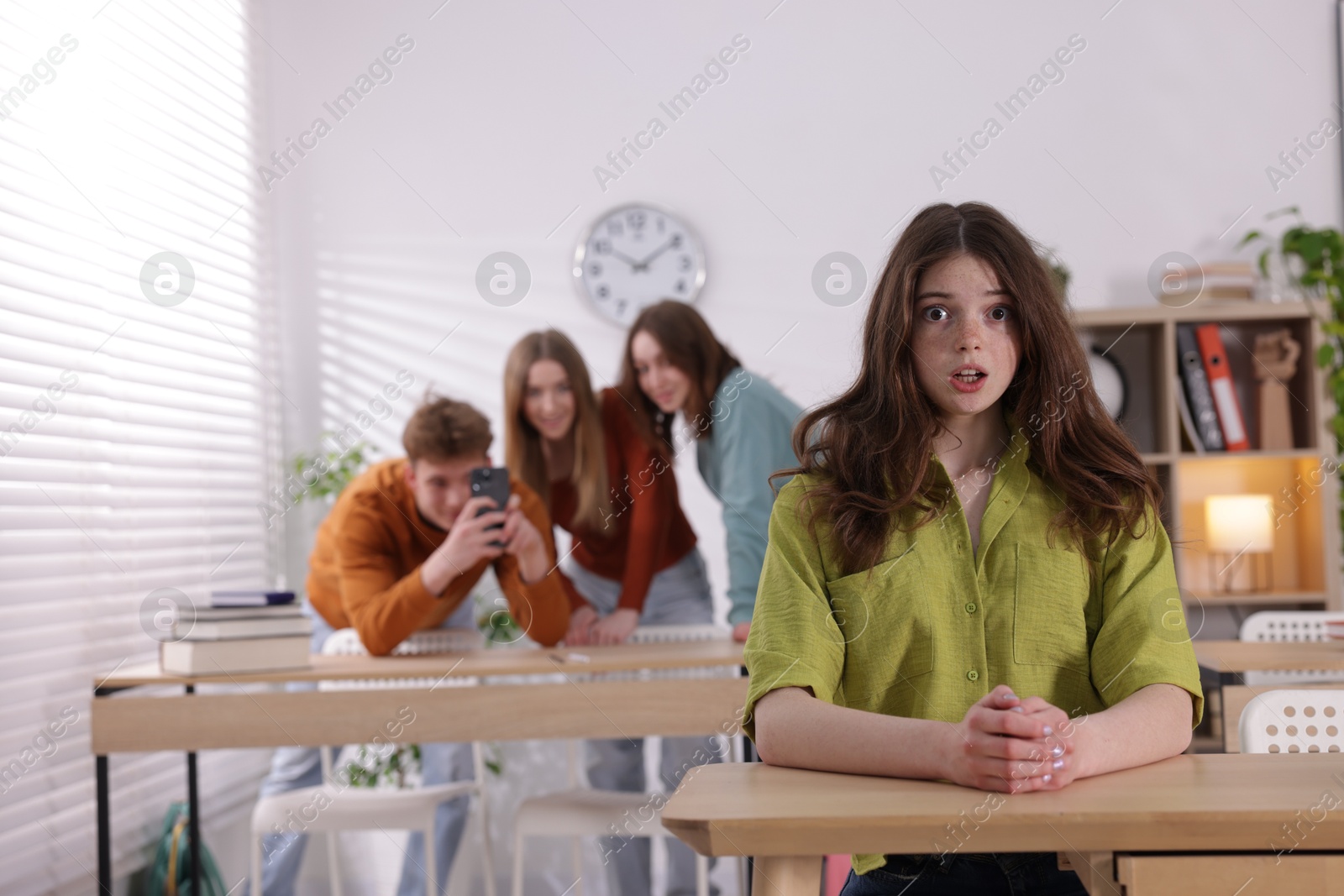 Photo of Teenage girl suffering from bullying at school, selective focus