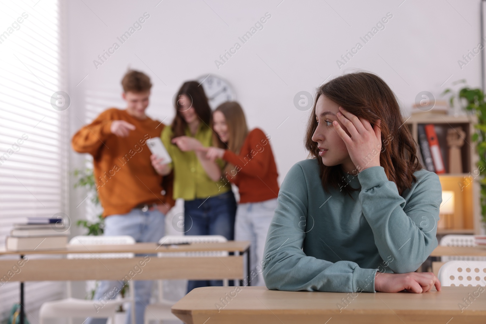 Photo of Teenage girl suffering from bullying at school, selective focus