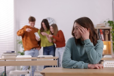 Photo of Teenage girl suffering from bullying at school, selective focus
