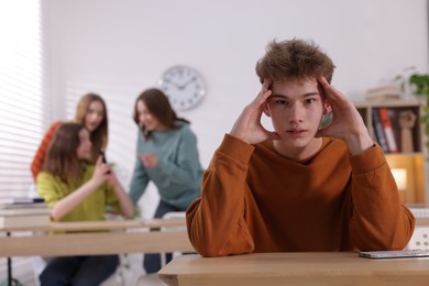 Photo of Teenage boy suffering from bullying at school, selective focus