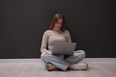 Photo of Cyber bullying. Upset teenage girl with laptop on floor indoors