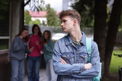 Photo of Teenage boy suffering from bullying at school, selective focus