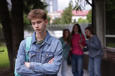 Photo of Teenage boy suffering from bullying at school, selective focus