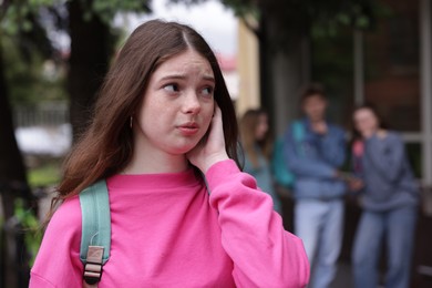 Photo of Teenage girl suffering from bullying at school, selective focus