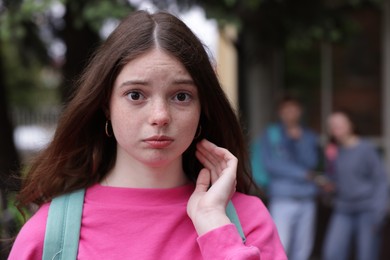 Photo of Teenage girl suffering from bullying at school, selective focus