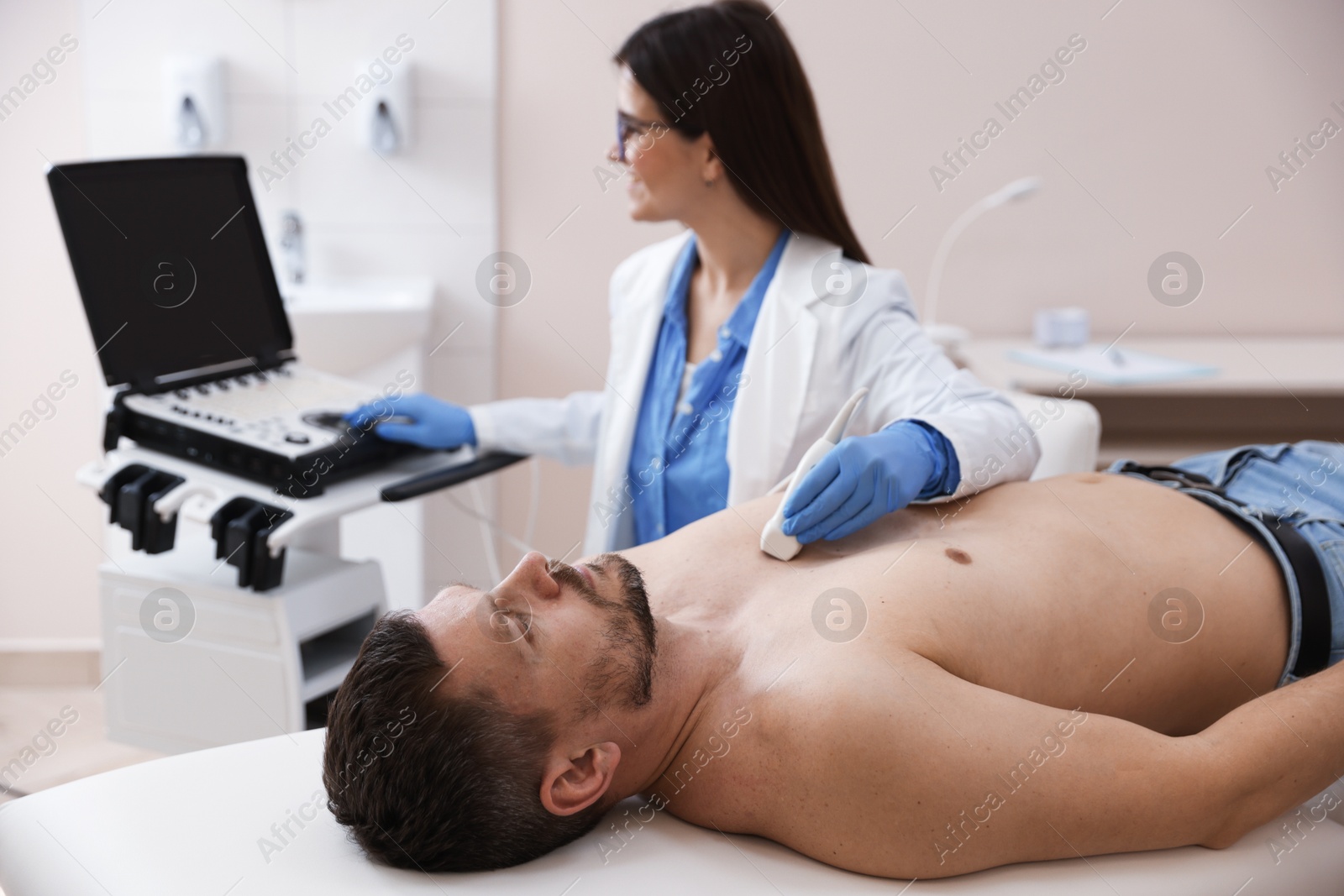 Sonographer conducting ultrasound examination of man's heart in clinic Photo of Sonographer conducting ultrasound examination of man's heart in clinic