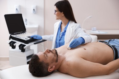Photo of Sonographer conducting ultrasound examination of man's heart in clinic