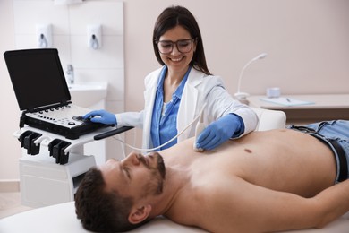 Photo of Sonographer conducting ultrasound examination of man's heart in clinic