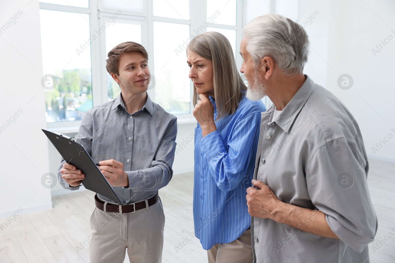 Real estate agent with clipboard working with couple at home Photo of Real estate agent with clipboard working with couple at home