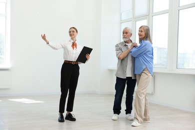 Photo of Smiling real estate agent showing apartment to couple indoors