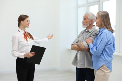 Photo of Smiling real estate agent showing apartment to couple indoors