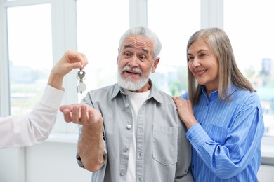 Photo of Real estate agent giving house key to new owner at home, closeup