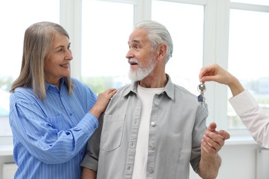 Photo of Real estate agent giving house key to new owner at home, closeup
