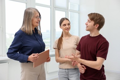 Photo of Real estate agent with tablet working with couple at home