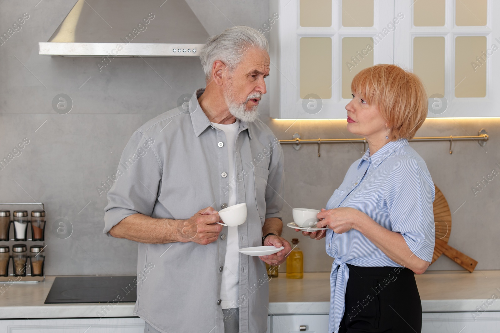 Lovely senior couple with cups of coffee in kitchen Photo of Lovely senior couple with cups of coffee in kitchen