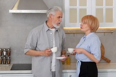 Photo of Lovely senior couple with cups of coffee in kitchen