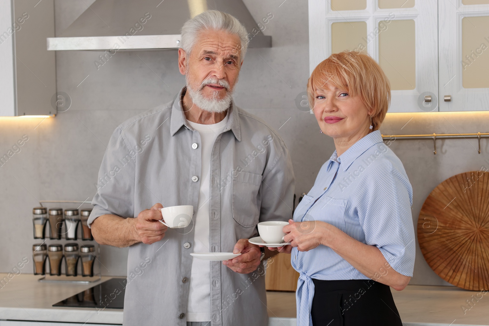 Lovely senior couple with cups of coffee in kitchen Photo of Lovely senior couple with cups of coffee in kitchen