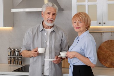 Photo of Lovely senior couple with cups of coffee in kitchen