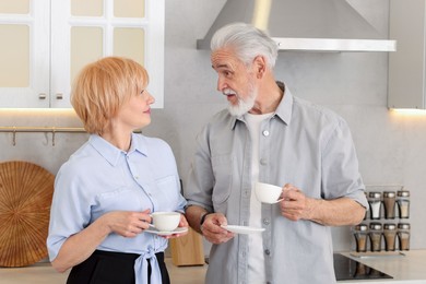Photo of Lovely senior couple with cups of coffee in kitchen