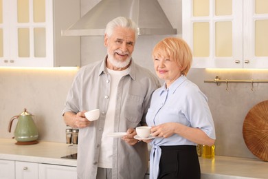 Photo of Lovely senior couple with cups of coffee in kitchen