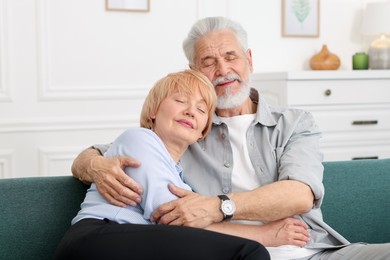 Photo of Lovely senior couple together on sofa at home