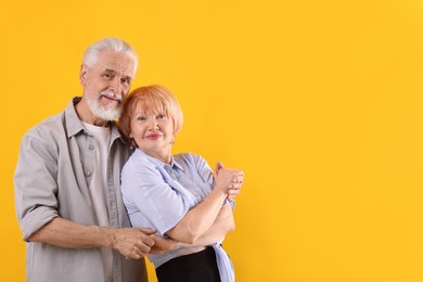 Photo of Lovely senior couple together on yellow background, space for text