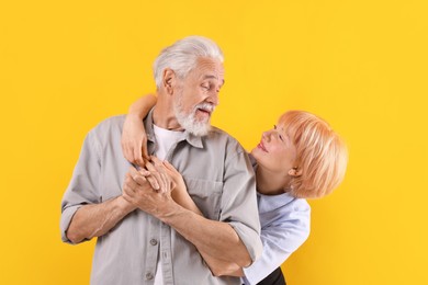 Photo of Lovely senior couple together on yellow background